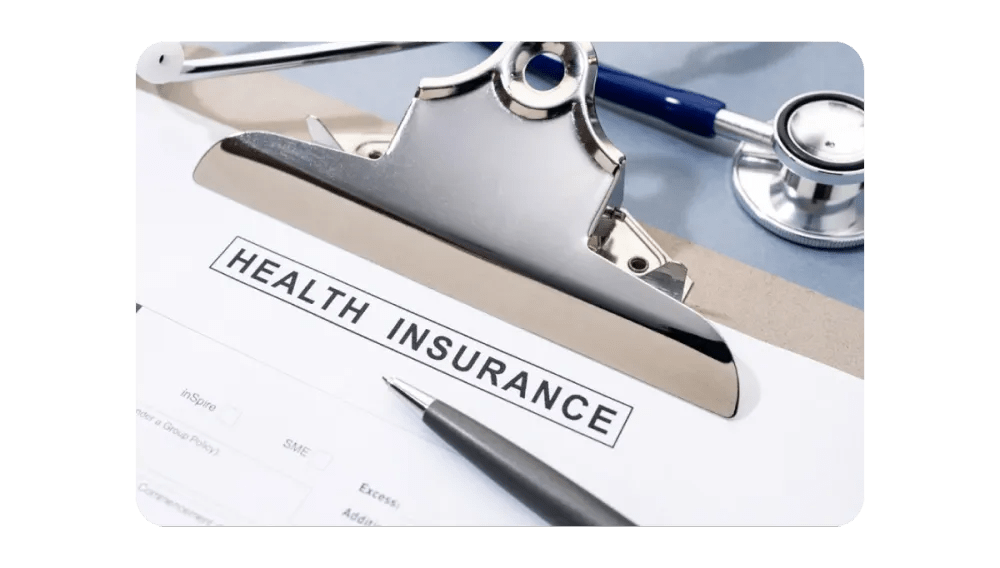 A health insurance form with a pen and stethoscope on a clipboard, representing healthcare documentation and plans.