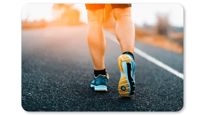 Close-up of a person walking on a road with running shoes, symbolizing participation in a step challenge