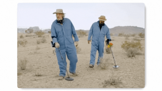 Employees searching a desert for hidden items during a scavenger hunt