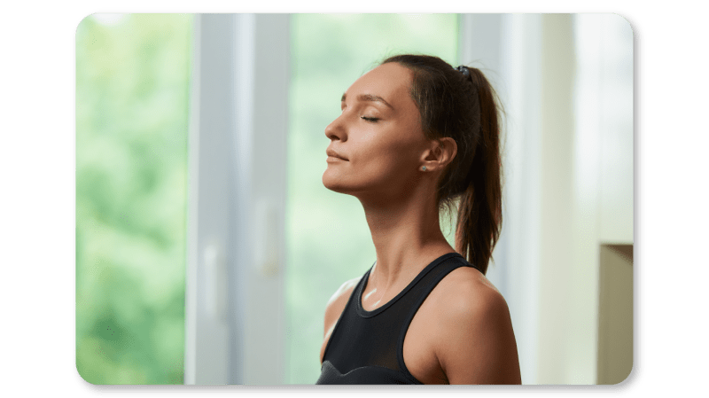 A woman practicing box breathing at her desk to steady her focus