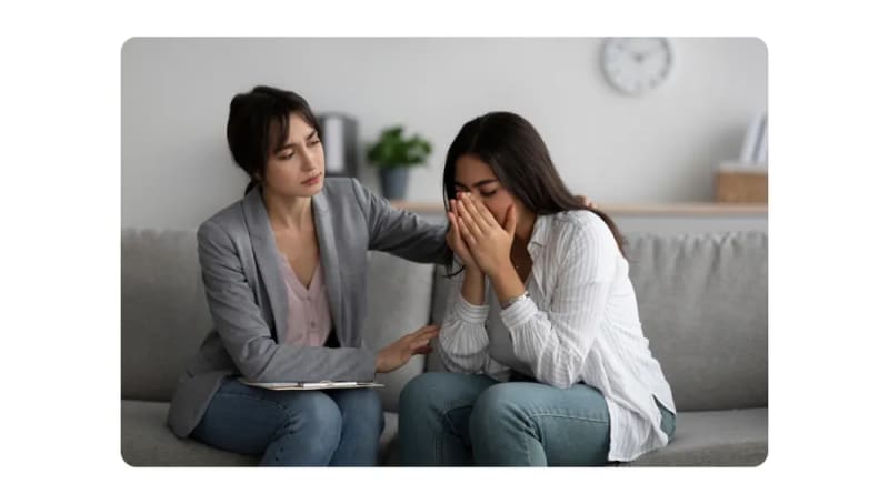 A concerned professional offering support to a distressed colleague during a one-on-one counseling session.png