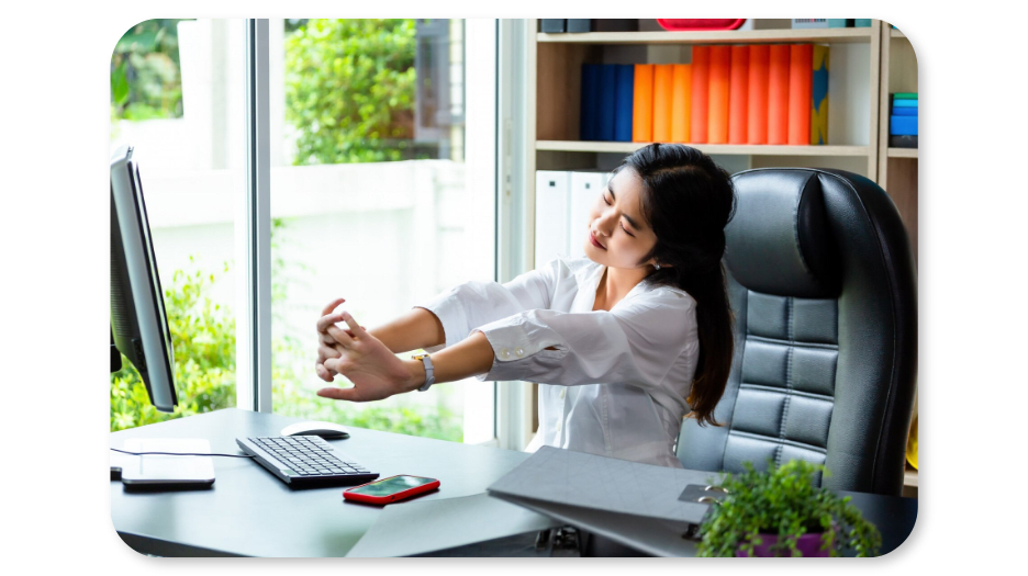 An employee stretches at her desk to reduce workplace stress